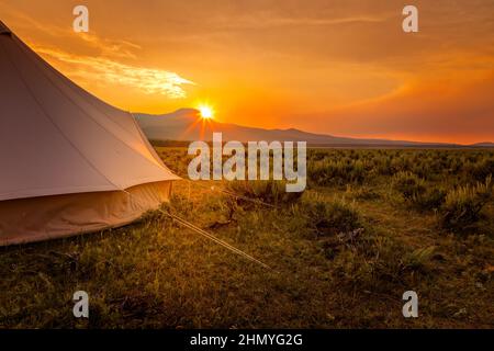 Tranquil campsite in the wilderness of Wyoming with the sun setting behind the mountains Stock Photo