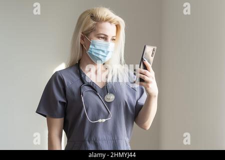 Doctor takes selfies on the phone. Nurse wearing a suit with a phone in his hands. Stock Photo