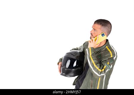 Motorcyclist calling on the phone with the helmet on his arm on a white background Stock Photo