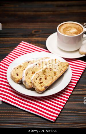 Slices of Traditional Christmas stollen cake with marzipan and dried fruit and cup of coffee Stock Photo