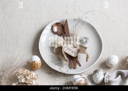 Festive Easter table setting with decor details on white table. Stock Photo