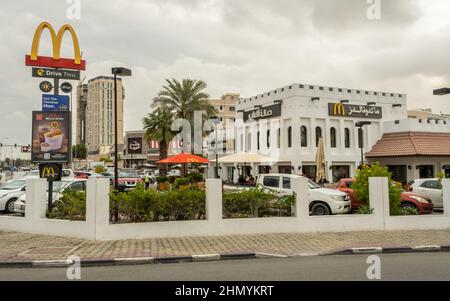 Doha, Qatar - January 16th 2022: A McDonald's restaurant, with people sitting outside in Doha, Qatar Stock Photo