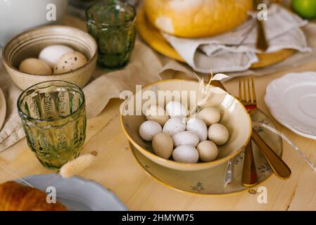 Boiled eggs in a plate stand on the table, a green glass glass. Easter Holiday Breakfast Stock Photo