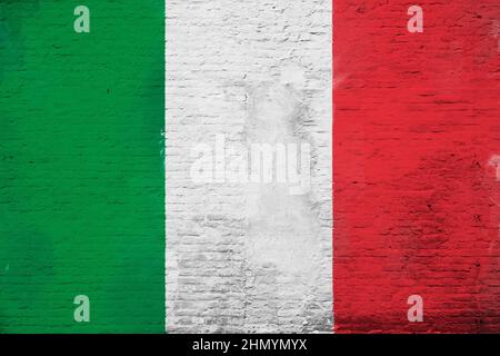 Full frame photo of a weathered flag of Italy painted on a plastered brick wall. Stock Photo