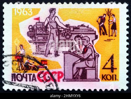 RUSSIA - CIRCA 1963: a stamp printed in Russia shows young people studying and working, circa 1963 Stock Photo