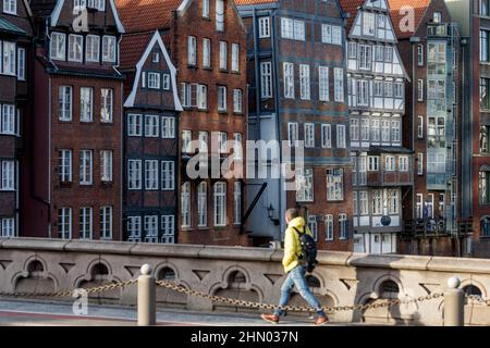 Hamburg, Germany. 12th Feb, 2022. A man walks across the Hohe BRücke past the historic town houses on Nikolaifleet. Credit: Markus Scholz/dpa//dpa/Alamy Live News Stock Photo