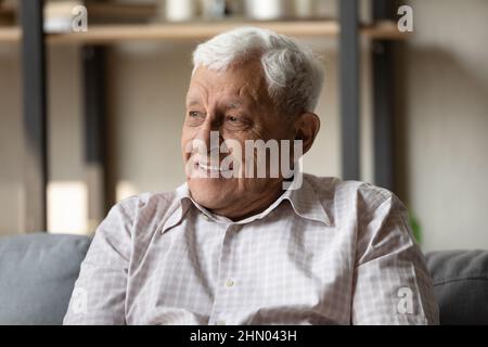 Positive pensive older 80s man looking away with good thoughts Stock Photo