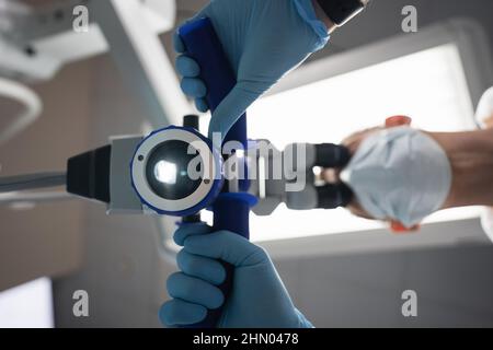 Dentist makes an operation using a dental microscope  Stock Photo