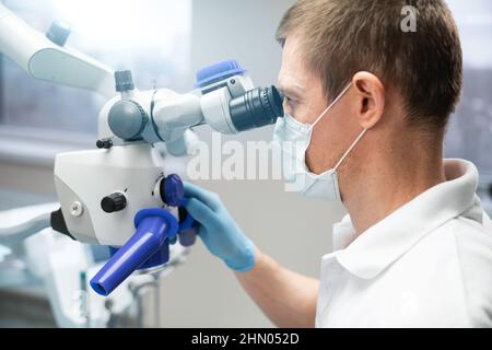 Dentist makes an operation using a dental microscope  Stock Photo