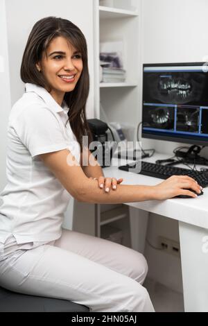 Woman dentist working at a computer in an x-ray room  Stock Photo