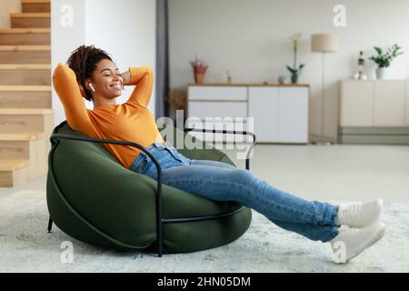 Calm black woman having rest at home on bean bag Stock Photo