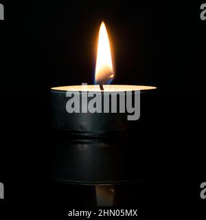 Candle Lit or Tealight is Burning on black background Stock Photo