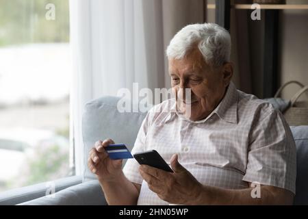 Focused man using mobile phone and making online payment Stock Photo