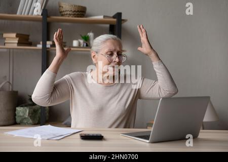 Frustrated angry landlady woman using laptop computer Stock Photo