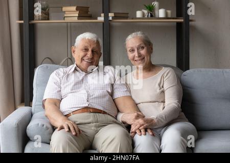 Happy old family couple resting on couch head shot portrait Stock Photo