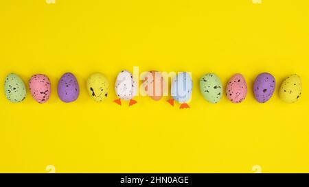 Creative Easter colorful layout with eggs on vibrant yellow background. Flat lay spring concept. Stock Photo