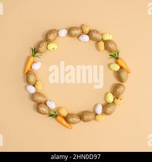 Creative copy space circle frame for Easter with eggs and carrots on pastel beige background. Flat lay minimal. Stock Photo