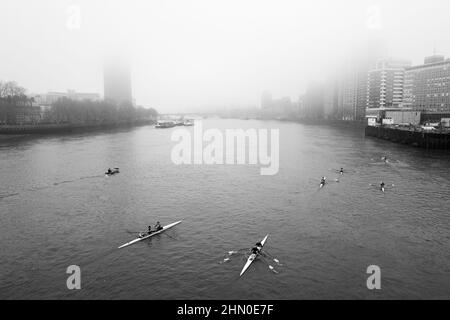 Rowers appear from under Vauxhall Bridge on a cold and misty London morning. London UK Stock Photo