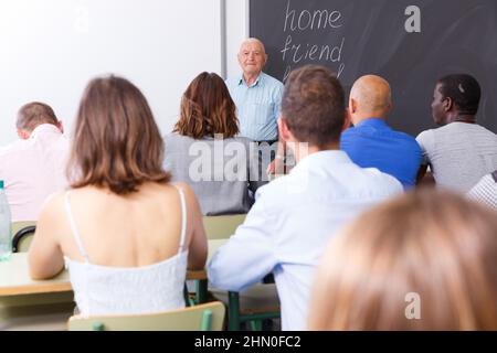 Mature teacher standing in front of students Stock Photo