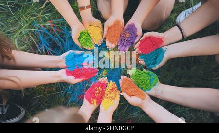 Holi paints in the hands of girls. Hands in a circle. Stock Photo