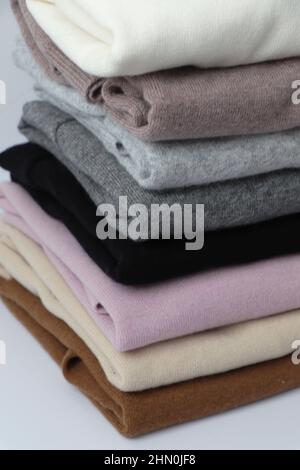 Pile or stack of colorful, folded cashmere or merino wool jumpers. Stock Photo