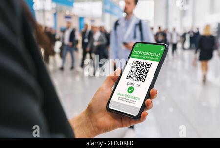 Green Pass Certificate of immunity against Covid19 on a mobile phone. Close up of businesswoman holding a smartphone screen application certicy that h Stock Photo