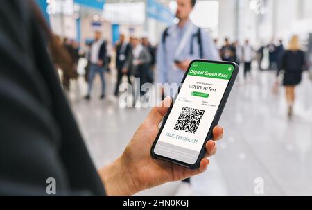 Green Pass Certificate of immunity against Covid19 on a mobile phone. Close up of businesswoman holding a smartphone screen application certicy that h Stock Photo