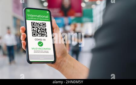 Female hand holding black cellphone with white screen at a trade fair, copyspace for your individual text. Stock Photo