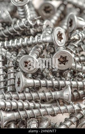 Close-up of universal silver screws with torx head. Self-tapping screws for wood, plywood or chipboard. Torx screws close up. Stock Photo