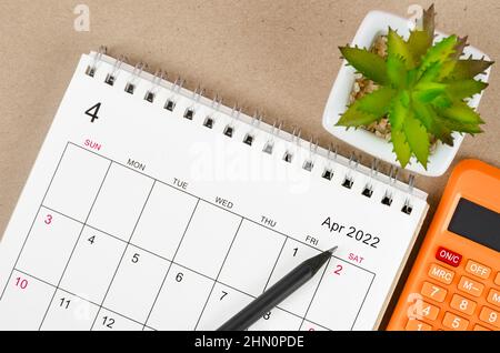 The April 2022 desk calendar with calculator. Stock Photo