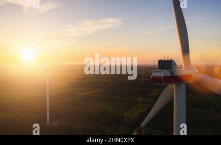 Beautiful sunset above the windmills on the field Stock Photo