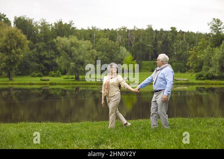 Senior man and woman holding hands in the park Stock Photo