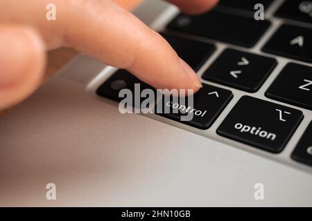 Hand pressing control key on modern laptop keyboard. Control sign and symbol closeup Stock Photo