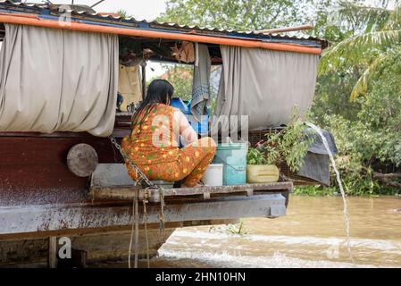 Vietnamese woman working on a house boat on the Mekong River, Mekong Delta, Vinh Long Province, southern Vietnam, Southeast Asia Stock Photo