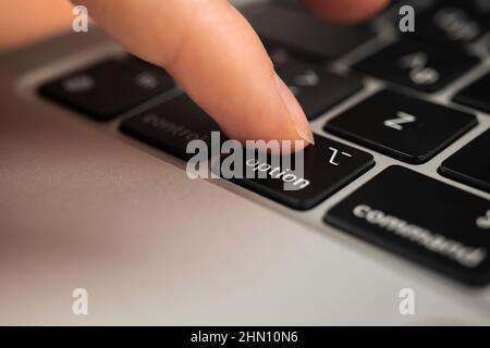 Hand pressing option key on modern laptop keyboard. Option sign and symbol closeup Stock Photo