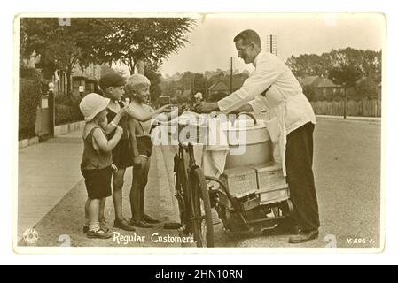 Original, archival, charming early 1920's era postcard of 3 young boys buying ice cream (cornet cornets) cones, from an ice cream vendor man selling ices from a bicycle, in a suburban English street on a hot summers day, boxes of Crawford's wafers on the back, circa 1920, U.K. Stock Photo
