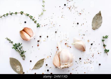 Different spices and garlic on light grey background, top view. Stock Photo