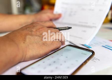 A businessman working on some documents and doing some calculations. Stock Photo