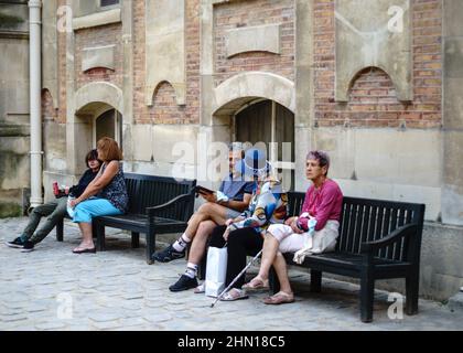 VERSAILLES PALACE, FRANCE - SEPTEMBER 25, 2021: People resting after walking in Versailles Palace. Stock Photo