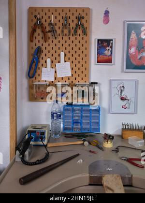 Workplace of an artisan jeweler in her workshop with various tools and the workbench. Stock Photo