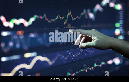 Businessman hand analysing financial stock market graph on board. Trading data index investment growth chart. Cryptocurrency and Forex Concept. Stock Photo