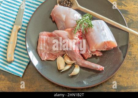 raw rabbit in a plate on a wooden table Stock Photo