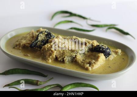 Kerala style, coconut based Pomfret fish curry. Yellow coloured fish curry shot on white background Stock Photo