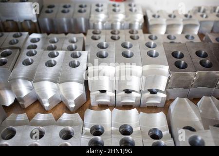 Manufacturing metal components for construction work inside a factory. Many steel pieces. Pattern repetition Stock Photo