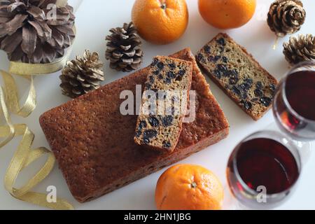 Slices of boiled fruit cake. An easy fruit cake with no alcohol. Made using dry fruits boiled in orange juice. Shot on white background along with red Stock Photo