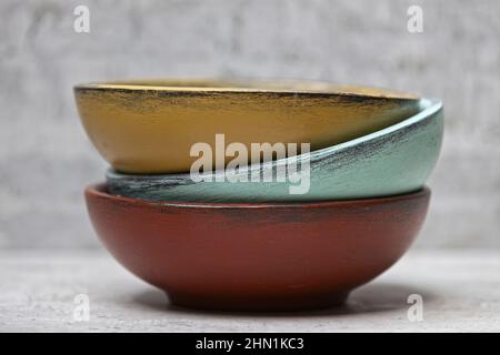A close up studio photo of three different colored wooden bowls stacked together. Stock Photo