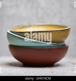 A close up studio photo of three different colored wooden bowls stacked together. Stock Photo