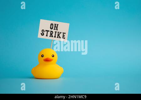 Rubber duck carries a signboard with the message of on strike. Social movements, workers going on strike concept. Stock Photo