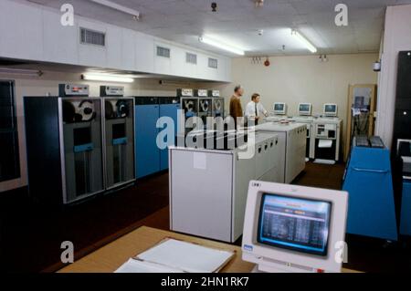 A mid-1980s view inside the Port Talbot Steelworks, an integrated steel production plant in Port Talbot, West Glamorgan, Wales, UK. This is a view of the company’s computer room. Massive mainframe computers were starting to play a big role in industry at this time. An IBM screen is in the foreground. Laptops and tablets now have the computing power and speed to take over from the sizeable, defunct early machines. This image is from a vintage colour transparency – a vintage 1980s photograph. Stock Photo