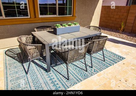 Back Patio Table And Six Chairs On Decorative Rug Stock Photo